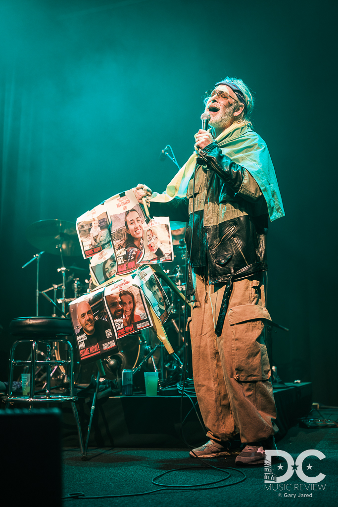 Matisyahu lifts up the chair with images of current Israeli hostages while performing "Lord Raise Me Up"
